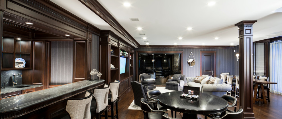 Large classic look-out basement in New York with a home bar, grey walls, medium hardwood flooring, no fireplace, brown floors and wallpapered walls.