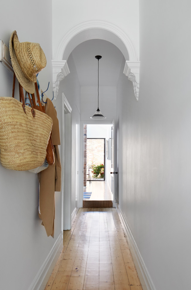 Inspiration for a traditional hallway in Melbourne with grey walls and light hardwood floors.