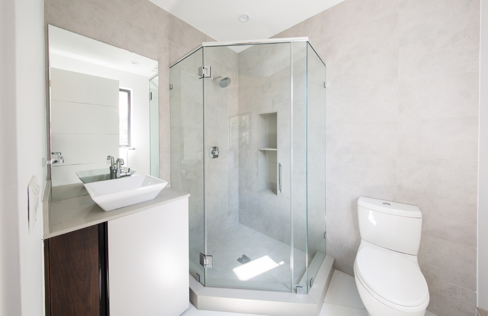 Inspiration for a small contemporary 3/4 bathroom in Los Angeles with flat-panel cabinets, white cabinets, a corner shower, a two-piece toilet, gray tile, cement tile, grey walls, ceramic floors, a vessel sink, solid surface benchtops, white floor and a hinged shower door.