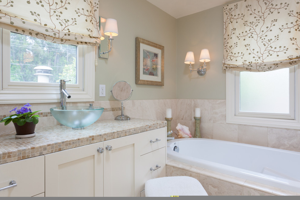 Photo of a mid-sized transitional master bathroom in San Francisco with a vessel sink, furniture-like cabinets, white cabinets, marble benchtops, an alcove tub, a double shower, a one-piece toilet, multi-coloured tile, stone tile, green walls, limestone floors, brown floor, a hinged shower door and beige benchtops.