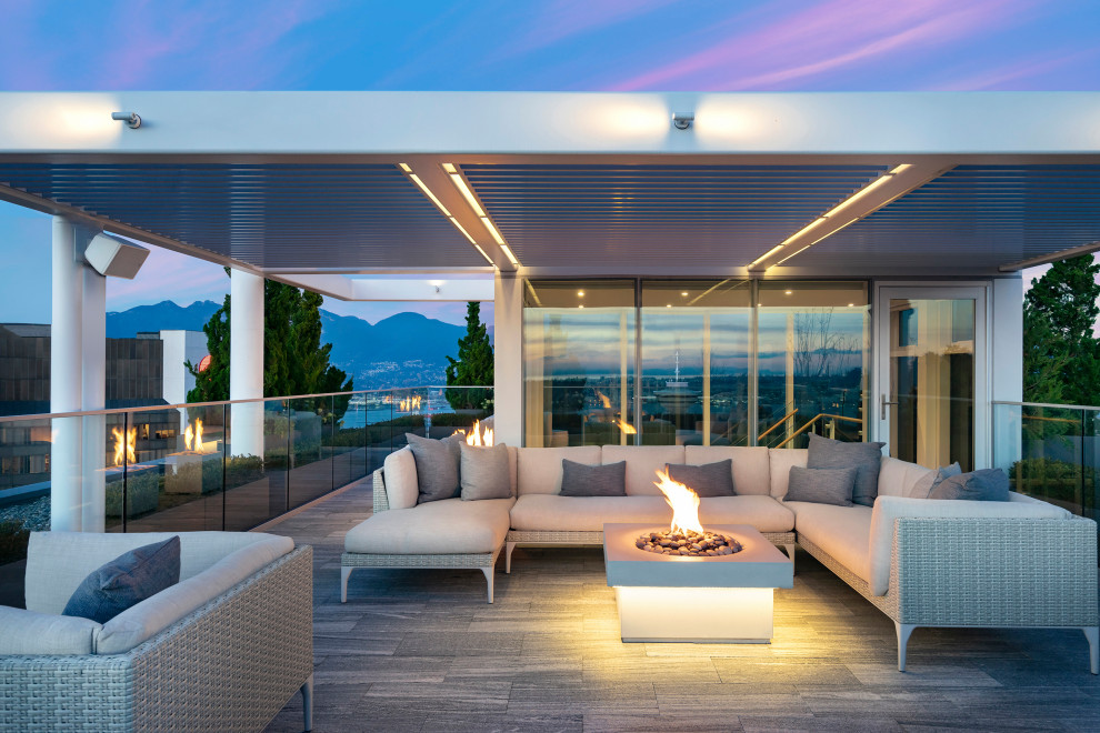 Design ideas for a contemporary deck in Los Angeles with a fire feature and a roof extension.