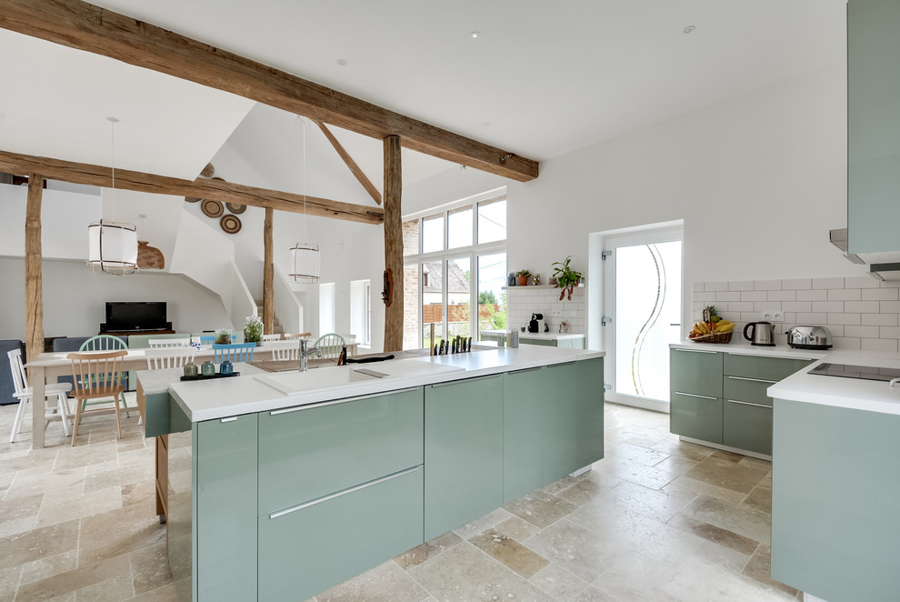Large eclectic l-shaped open plan kitchen in Paris with an undermount sink, flat-panel cabinets, green cabinets, laminate benchtops, white splashback, subway tile splashback, panelled appliances, marble floors, with island and beige floor.
