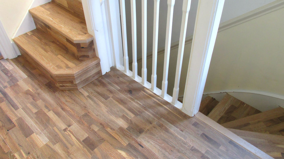 Inspiration for a mid-sized contemporary wood curved staircase in London with wood risers.