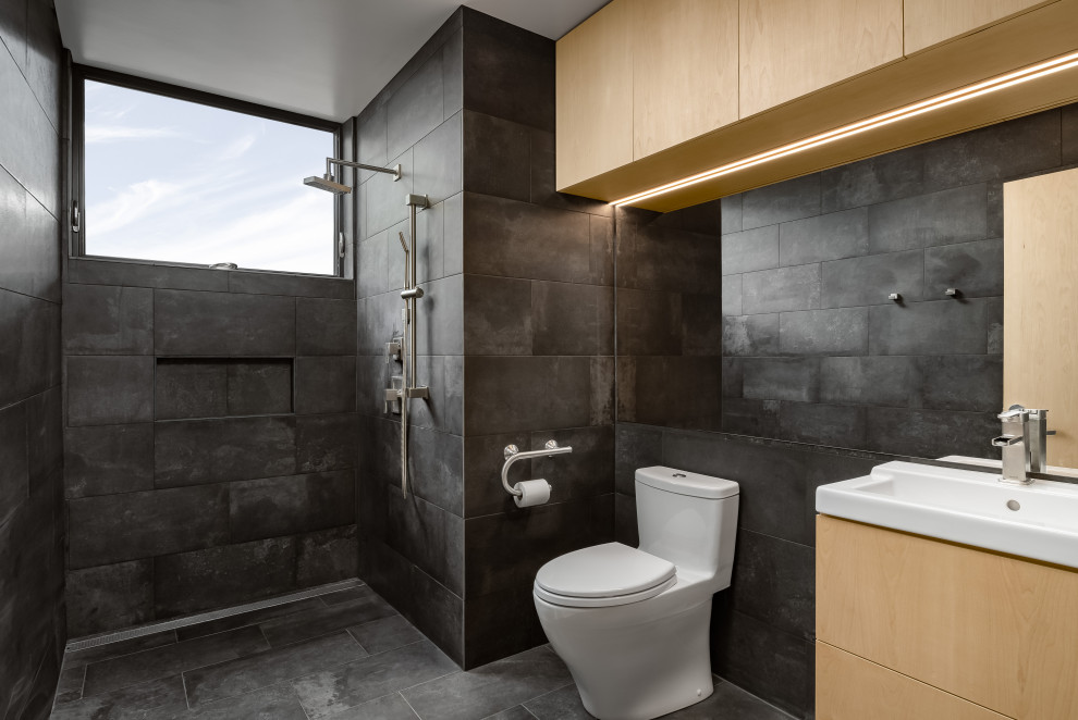 Стильный дизайн: маленькая главная ванная комната в современном стиле с плоскими фасадами, светлыми деревянными фасадами, душем без бортиков, унитазом-моноблоком, серой плиткой, керамической плиткой, серыми стенами, полом из керамической плитки, монолитной раковиной, серым полом, открытым душем, белой столешницей, тумбой под одну раковину и подвесной тумбой для на участке и в саду - последний тренд