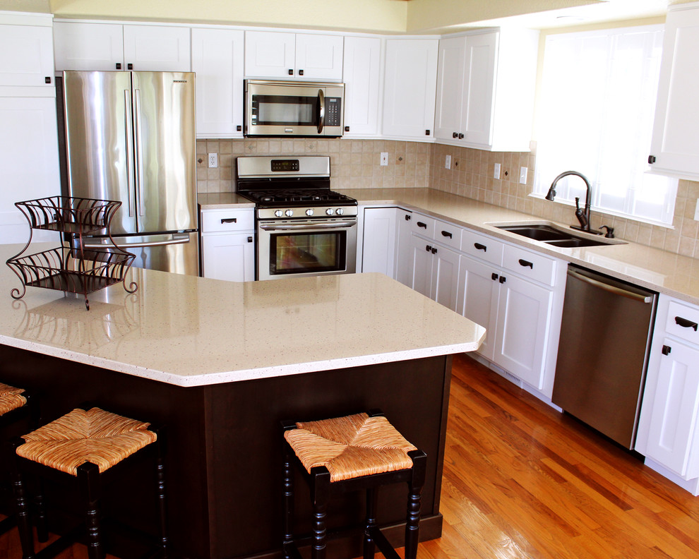Eat-in kitchen - mid-sized transitional l-shaped light wood floor eat-in kitchen idea in Boise with an undermount sink, shaker cabinets, white cabinets, quartz countertops, beige backsplash, terra-cotta backsplash, stainless steel appliances and an island