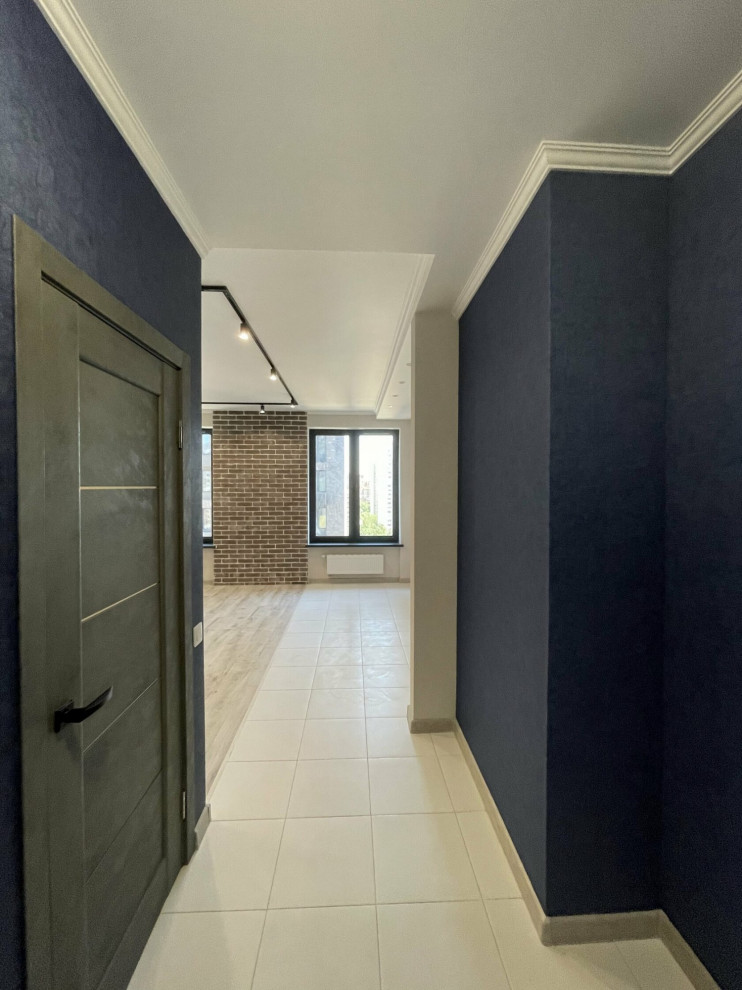 Réalisation d'un petit couloir design avec un mur bleu, sol en stratifié, un sol gris et du papier peint.