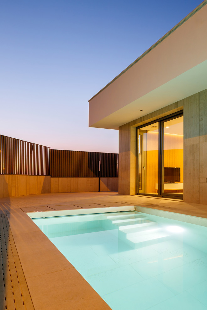 Foto di una piscina monocorsia design rettangolare di medie dimensioni e nel cortile laterale con paesaggistica bordo piscina e piastrelle