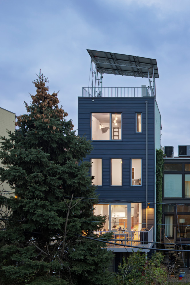 Mittelgroßes, Vierstöckiges Modernes Reihenhaus mit Faserzement-Fassade, blauer Fassadenfarbe, Flachdach, Misch-Dachdeckung und Verschalung in New York