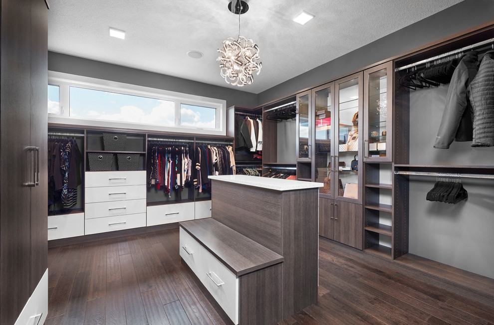 Design ideas for a large contemporary gender-neutral walk-in wardrobe in Edmonton with louvered cabinets, dark wood cabinets, dark hardwood floors and brown floor.