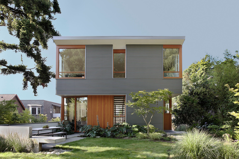 Inspiration for a mid-sized modern two-storey grey house exterior in Seattle with mixed siding and a flat roof.