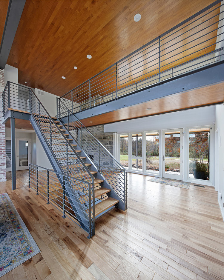 This is an example of an industrial wood straight staircase in Philadelphia with open risers and metal railing.