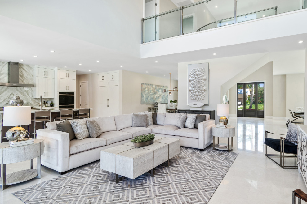 This is an example of a contemporary open concept living room in Miami with white walls and white floor.