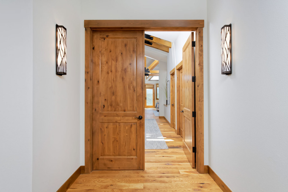 Idee per un ingresso o corridoio rustico di medie dimensioni con pareti blu e pavimento in legno massello medio