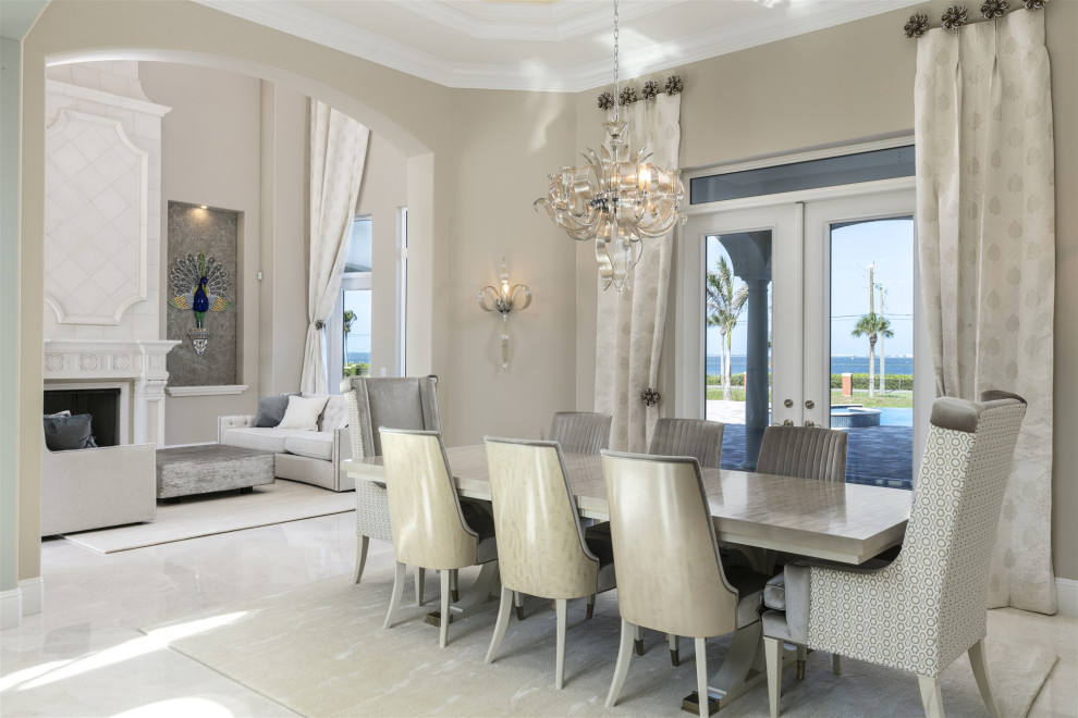 Inspiration for a large contemporary dining room in Orlando with beige walls, marble floors, a standard fireplace, a stone fireplace surround, beige floor and recessed.