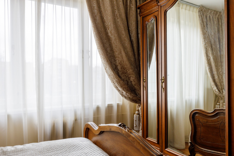 Photo of a mid-sized traditional master bedroom in Moscow with beige walls, dark hardwood floors and brown floor.