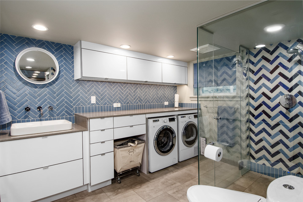 Design ideas for a mid-sized eclectic 3/4 bathroom in Seattle with flat-panel cabinets, white cabinets, a curbless shower, a one-piece toilet, blue tile, porcelain tile, grey walls, porcelain floors, a vessel sink, engineered quartz benchtops, grey floor and a hinged shower door.