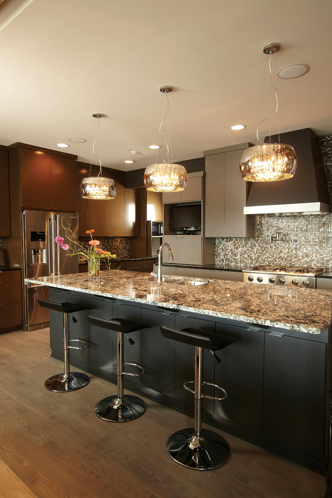 Example of a trendy l-shaped open concept kitchen design in New York with a drop-in sink, flat-panel cabinets, dark wood cabinets, granite countertops, gray backsplash, mosaic tile backsplash and stainless steel appliances