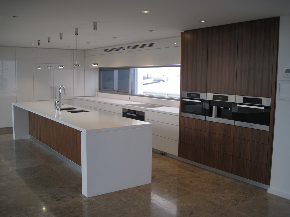 Design ideas for a modern kitchen in Perth with white cabinets, with island, an undermount sink, flat-panel cabinets, quartz benchtops, white splashback, stone slab splashback, stainless steel appliances and travertine floors.