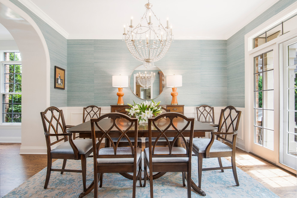 This is an example of a mid-sized transitional separate dining room in Chicago with blue walls, medium hardwood floors, brown floor, no fireplace and wallpaper.