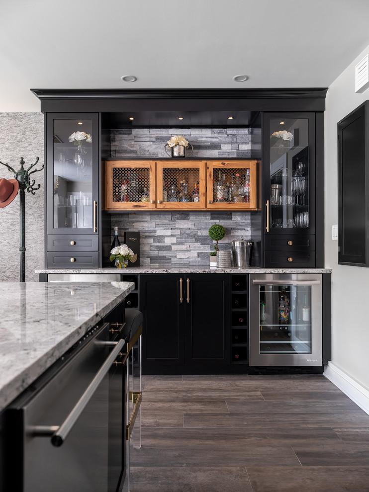 Transitional single-wall home bar in Boston with no sink, glass-front cabinets, black cabinets, grey splashback, brown floor and grey benchtop.