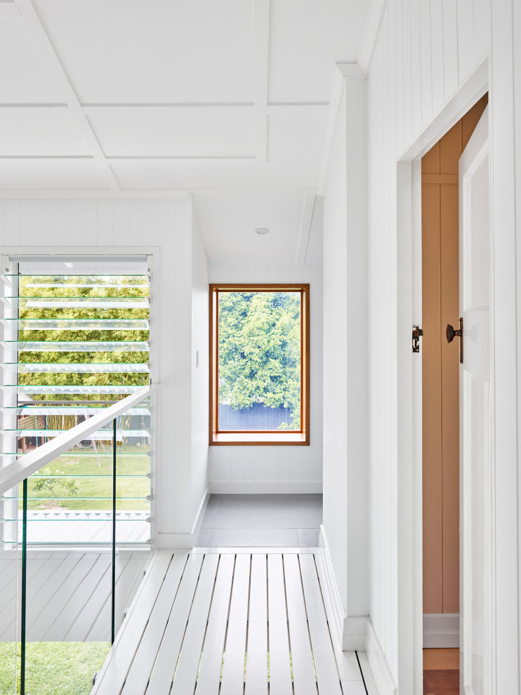 На фото: коридор среднего размера в современном стиле с белыми стенами, деревянным полом, белым полом, потолком из вагонки и панелями на стенах с