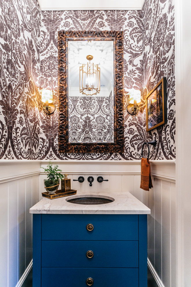 Example of a small transitional powder room design in Charleston with an undermount sink, furniture-like cabinets, blue cabinets, multicolored walls, marble countertops and white countertops
