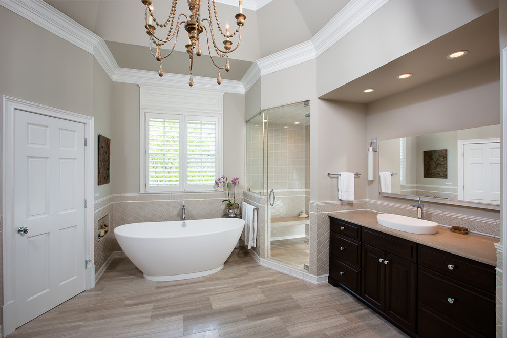 Design ideas for a large contemporary master bathroom in Atlanta with beige cabinets, a freestanding tub, a corner shower, ceramic tile, limestone floors, raised-panel cabinets, beige tile, beige walls, a vessel sink and granite benchtops.
