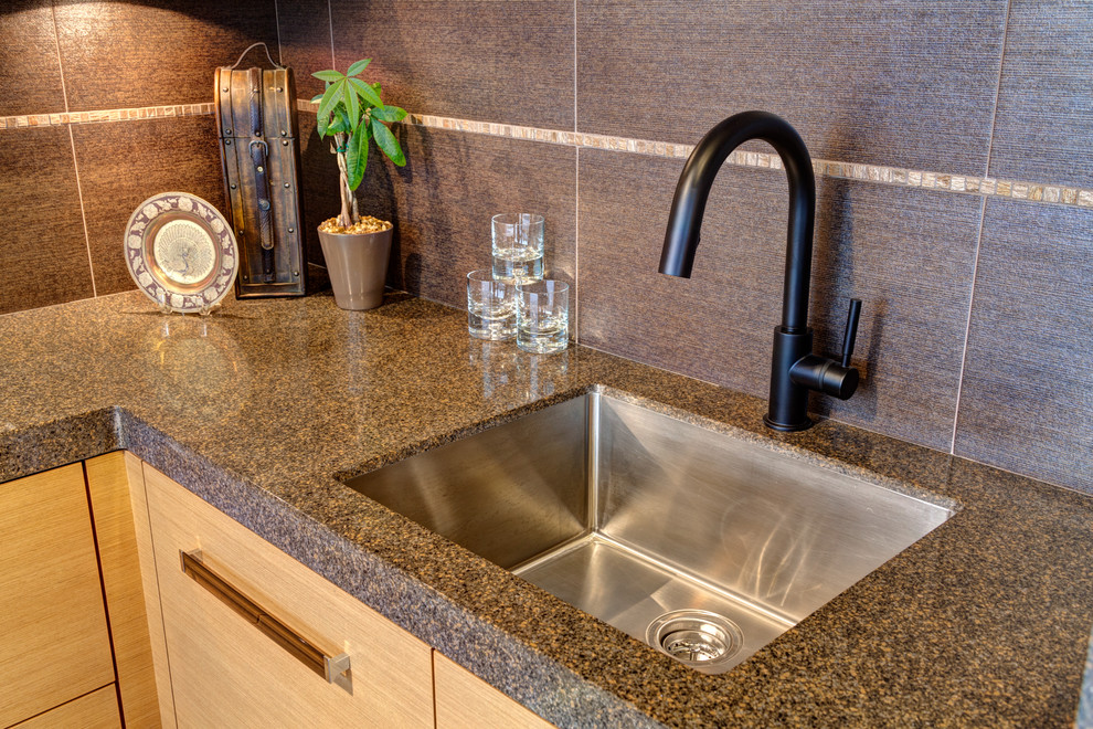 Mid-sized modern l-shaped wet bar in Chicago with an undermount sink, light wood cabinets, porcelain splashback, flat-panel cabinets, terrazzo benchtops, grey splashback, porcelain floors and beige floor.