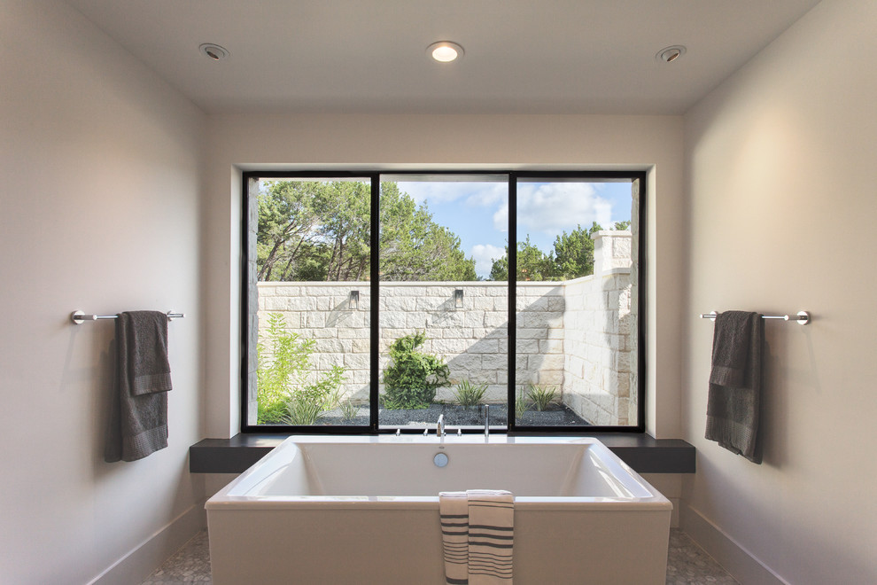 Inspiration for a contemporary master bathroom in Austin with a freestanding tub and white walls.