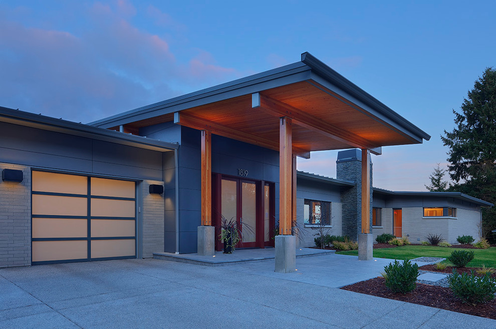 Inspiration for a large modern one-storey grey house exterior in Seattle with mixed siding and a flat roof.