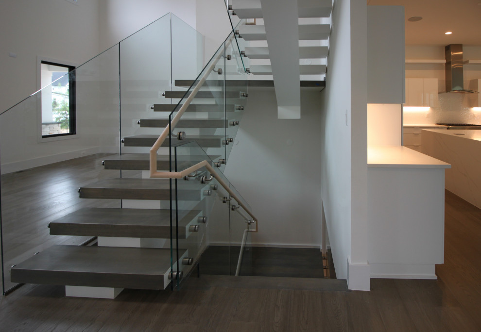 Photo of an expansive modern wood floating staircase in DC Metro with glass railing.