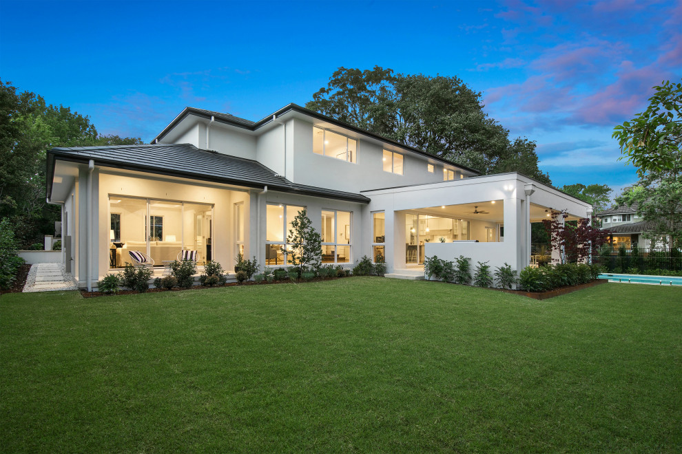 Photo of a large contemporary two-storey beige house exterior in Sydney with a gable roof and a tile roof.