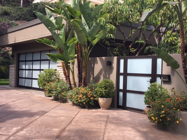 This is an example of a large tropical attached three-car garage in Los Angeles.