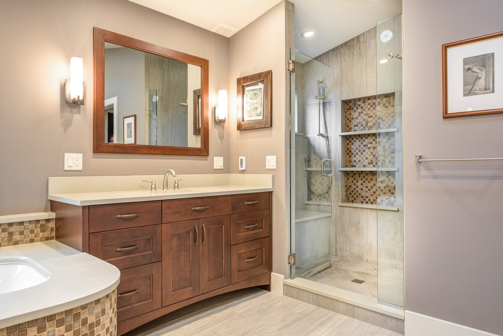 Photo of a large transitional master bathroom in Seattle with recessed-panel cabinets, medium wood cabinets, a corner tub, an alcove shower, a two-piece toilet, multi-coloured tile, ceramic tile, beige walls, an undermount sink and engineered quartz benchtops.