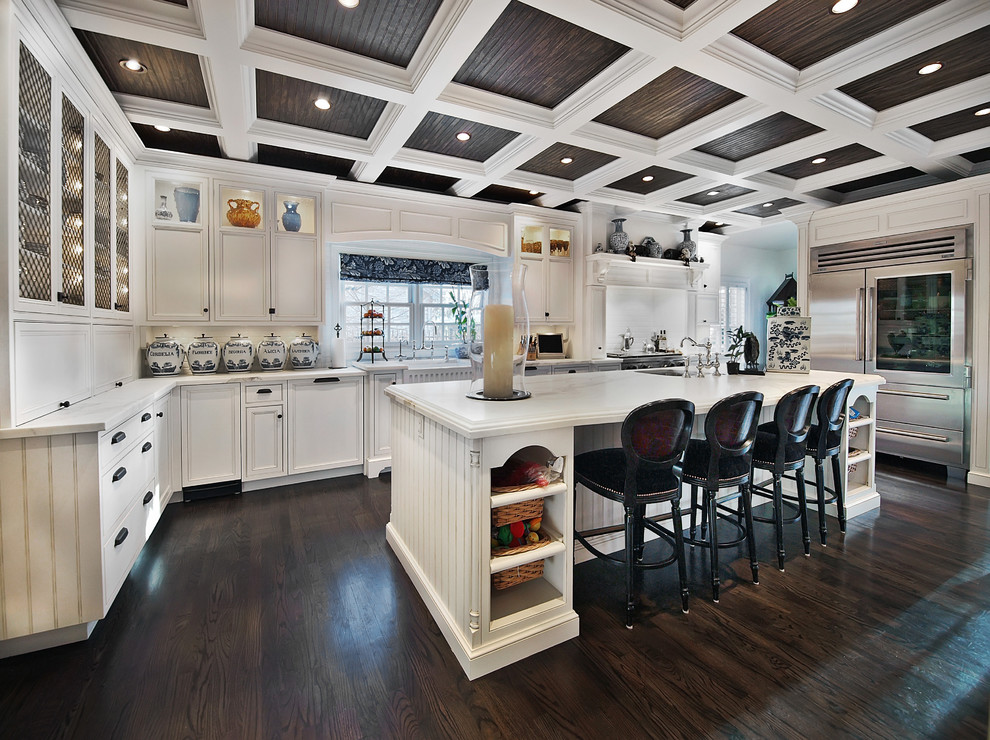 Traditional u-shaped kitchen in Denver with glass-front cabinets, white cabinets and stainless steel appliances.