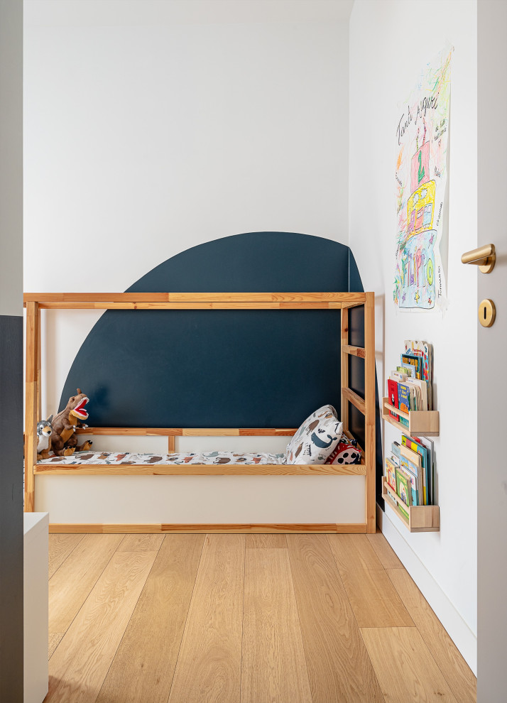 Aménagement d'une petite chambre d'enfant de 4 à 10 ans contemporaine avec un mur bleu et parquet clair.