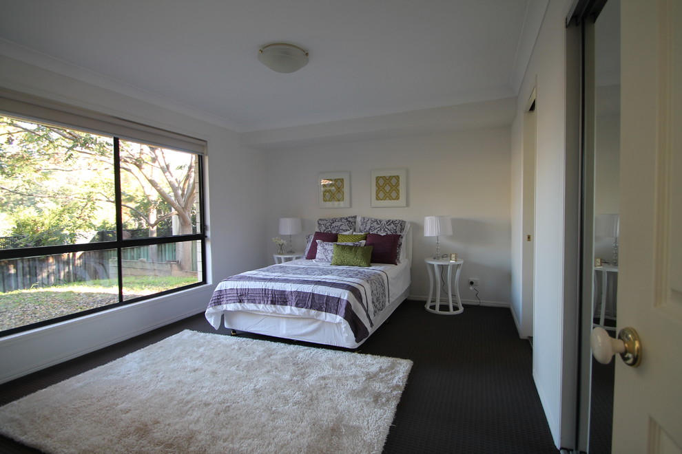 This is an example of a small contemporary bedroom in Sydney with white walls and carpet.
