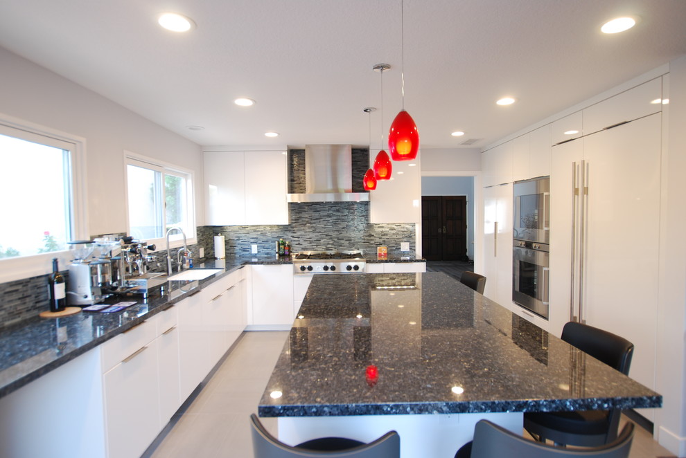 Photo of a large contemporary l-shaped eat-in kitchen in Los Angeles with a drop-in sink, flat-panel cabinets, white cabinets, solid surface benchtops, grey splashback, matchstick tile splashback, stainless steel appliances and with island.