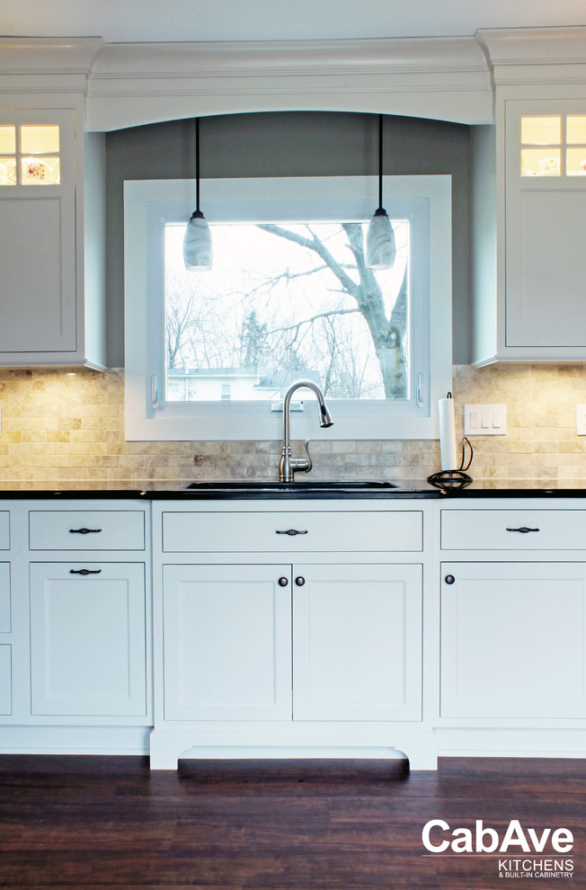 Eat-in kitchen - mid-sized transitional l-shaped vinyl floor and brown floor eat-in kitchen idea with an undermount sink, recessed-panel cabinets, white cabinets, quartz countertops, beige backsplash, ceramic backsplash, stainless steel appliances and no island