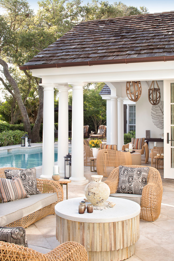 Design ideas for a large traditional backyard patio in Miami with tile and a roof extension.