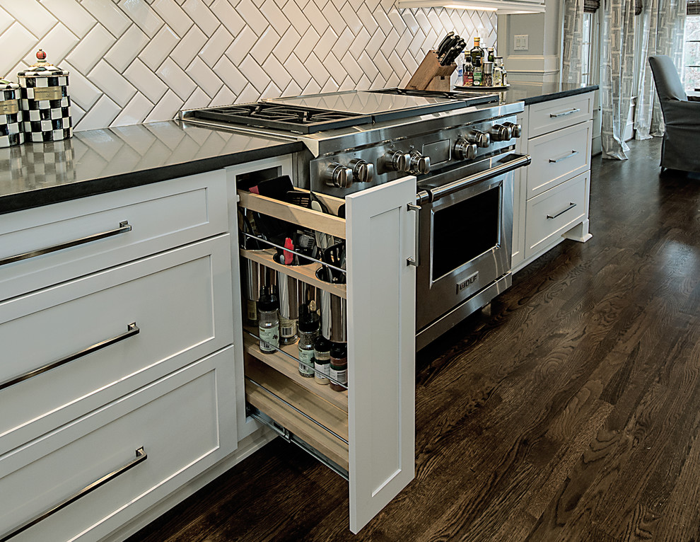 Large transitional l-shaped medium tone wood floor and brown floor open concept kitchen photo in Atlanta with a farmhouse sink, shaker cabinets, white cabinets, quartzite countertops, white backsplash, subway tile backsplash, stainless steel appliances and an island