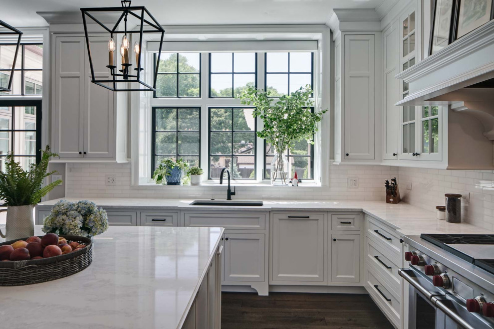 Eat-in kitchen - transitional l-shaped dark wood floor, brown floor and tray ceiling eat-in kitchen idea in Chicago with an undermount sink, recessed-panel cabinets, white cabinets, quartzite countertops, white backsplash, ceramic backsplash, stainless steel appliances, an island and white countertops