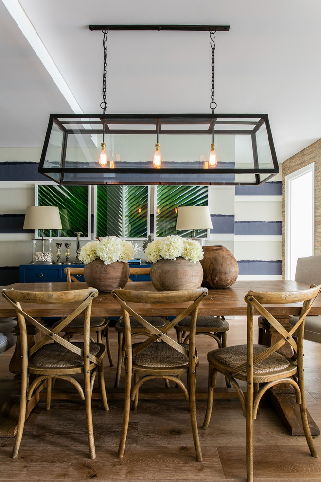 This is an example of a mid-sized beach style open plan dining in Sydney with multi-coloured walls, light hardwood floors and no fireplace.