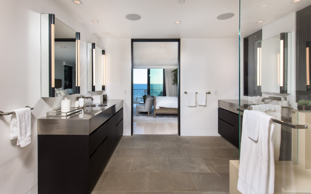 Design ideas for a large contemporary master bathroom in Los Angeles with flat-panel cabinets, black cabinets, a freestanding tub, a corner shower, a drop-in sink, stainless steel benchtops, a hinged shower door, a double vanity and a built-in vanity.