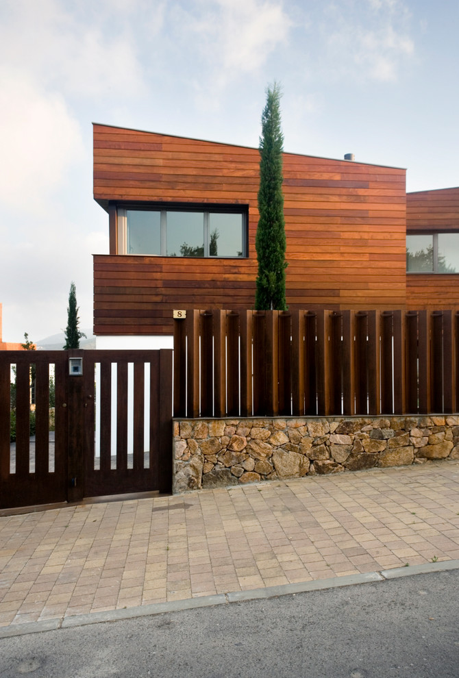 Photo of a mid-sized contemporary two-storey brown exterior in Barcelona with mixed siding and a shed roof.