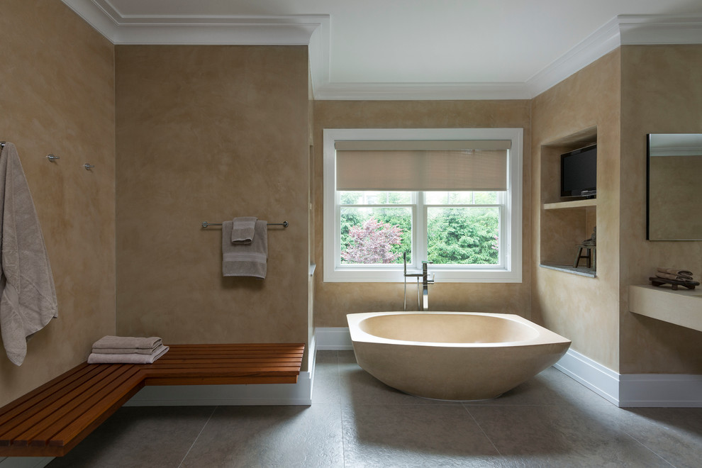Inspiration for a large asian master bathroom in New York with a freestanding tub, brown walls and grey floor.