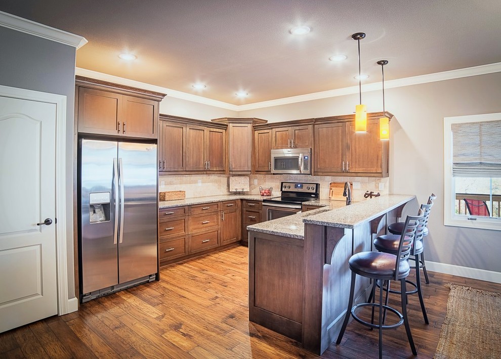 Mid-sized transitional u-shaped dark wood floor and brown floor eat-in kitchen photo with an undermount sink, shaker cabinets, dark wood cabinets, granite countertops, beige backsplash, ceramic backsplash, stainless steel appliances and a peninsula