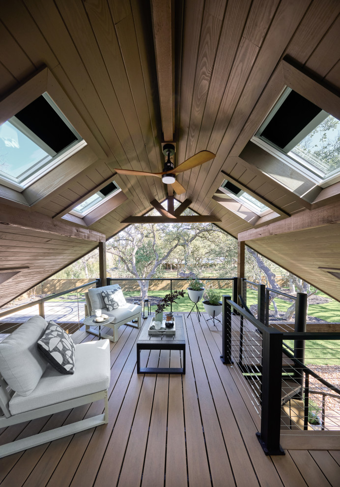 Example of a trendy second story cable railing deck design in Denver with a roof extension