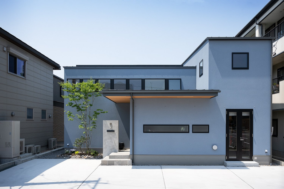 Cette photo montre une façade de maison bleue moderne en planches et couvre-joints de taille moyenne et à un étage avec un revêtement mixte, un toit en appentis, un toit en métal et un toit gris.