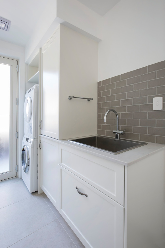 Inspiration for a mid-sized traditional galley dedicated laundry room in Sydney with a drop-in sink, shaker cabinets, white cabinets, quartz benchtops, beige splashback, ceramic splashback, white walls, porcelain floors, a side-by-side washer and dryer, beige floor, white benchtop and coffered.
